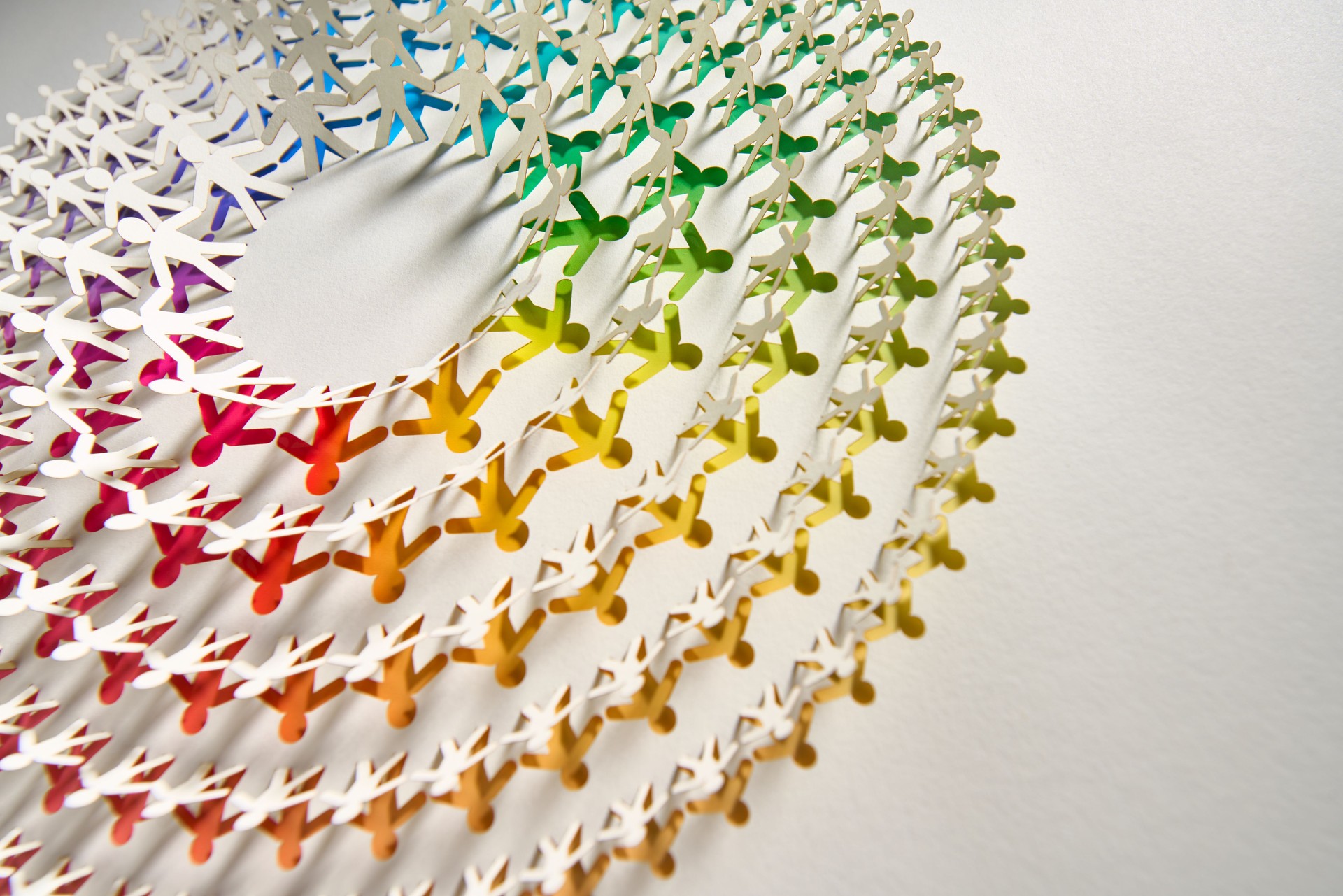 Intricate circular paper chain artwork with human shapes and vibrant rainbow gradient design